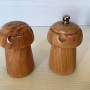 Salt and pepper shakers in wood shaped like a champagne cork.