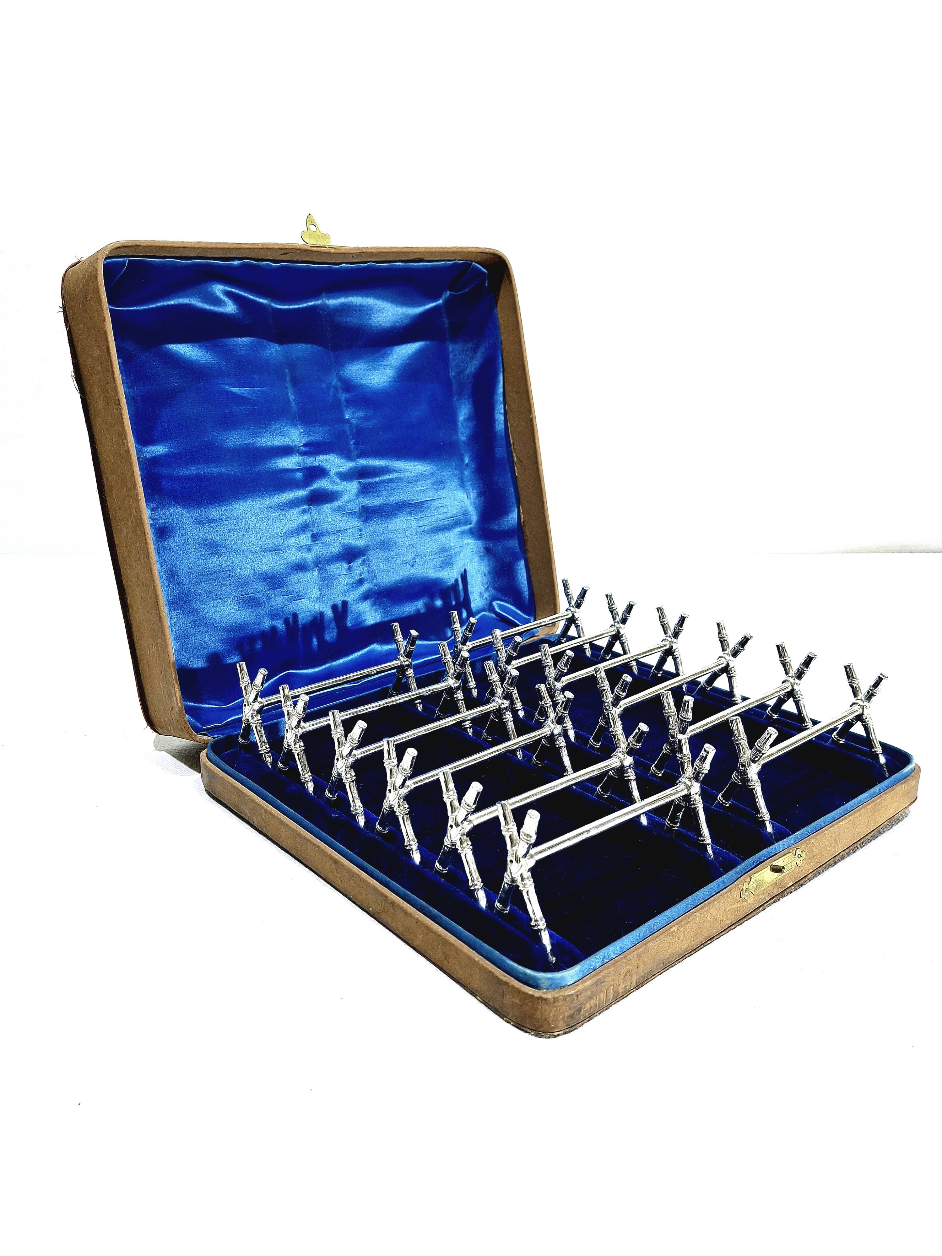 12 silver-plated metal knife handles, in a case.