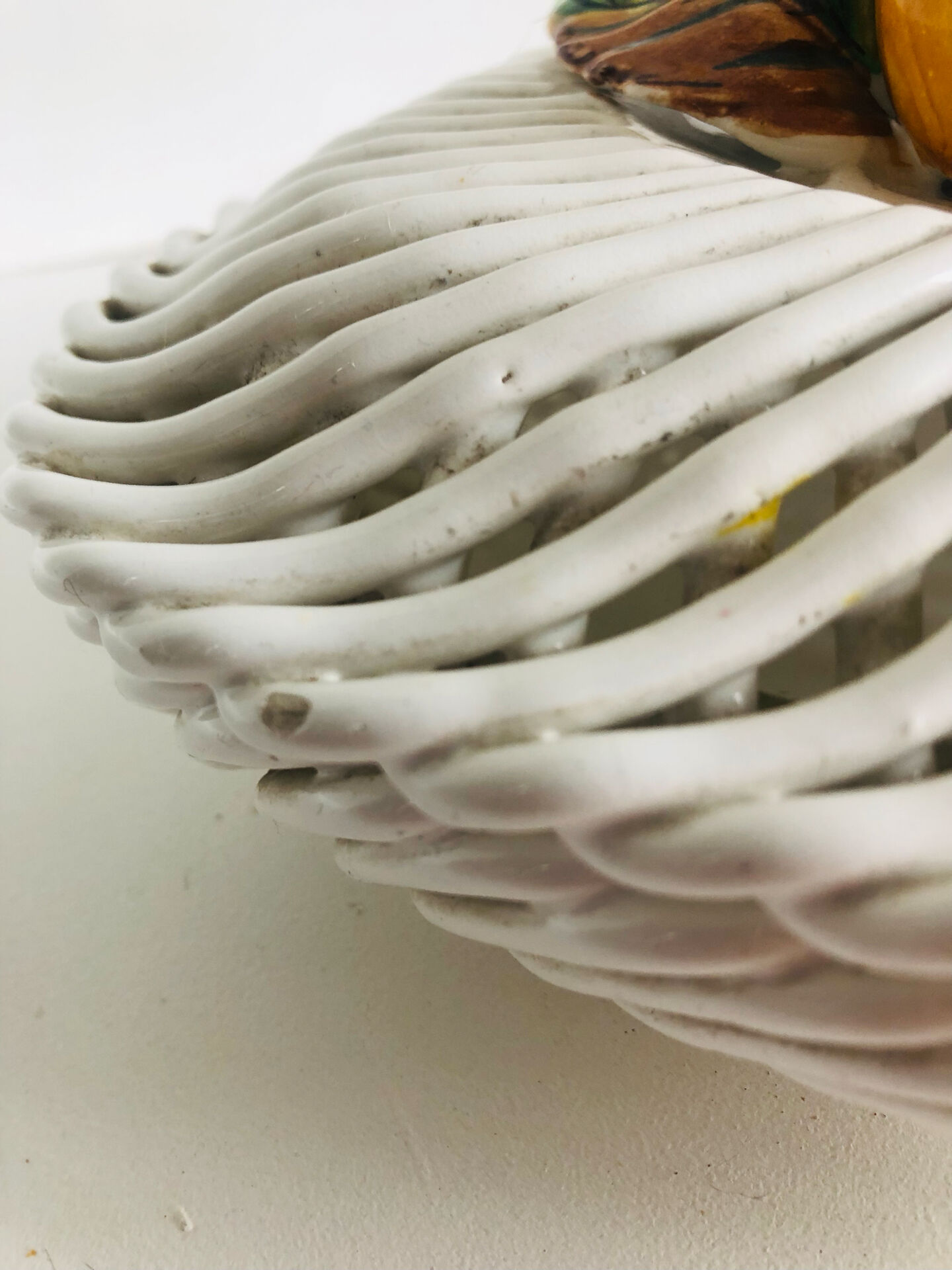 Covered basket in white woven ceramic and fruit slip.
