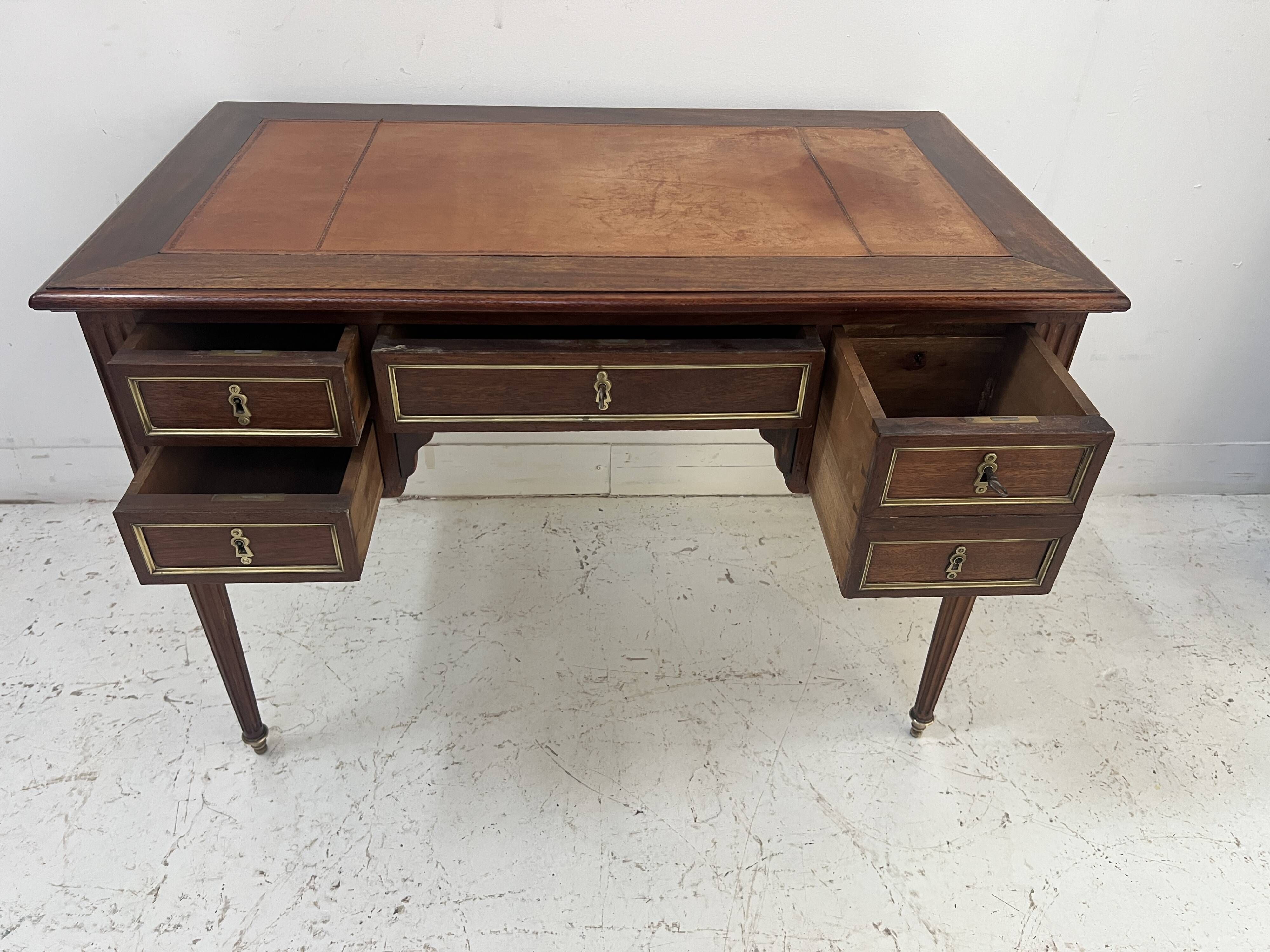 Louis XVI style desk in mahogany and mahogany veneer, 20th century.