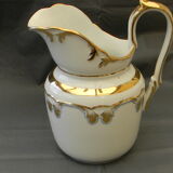 Milk jug or antique pitcher in white and gold porcelain.