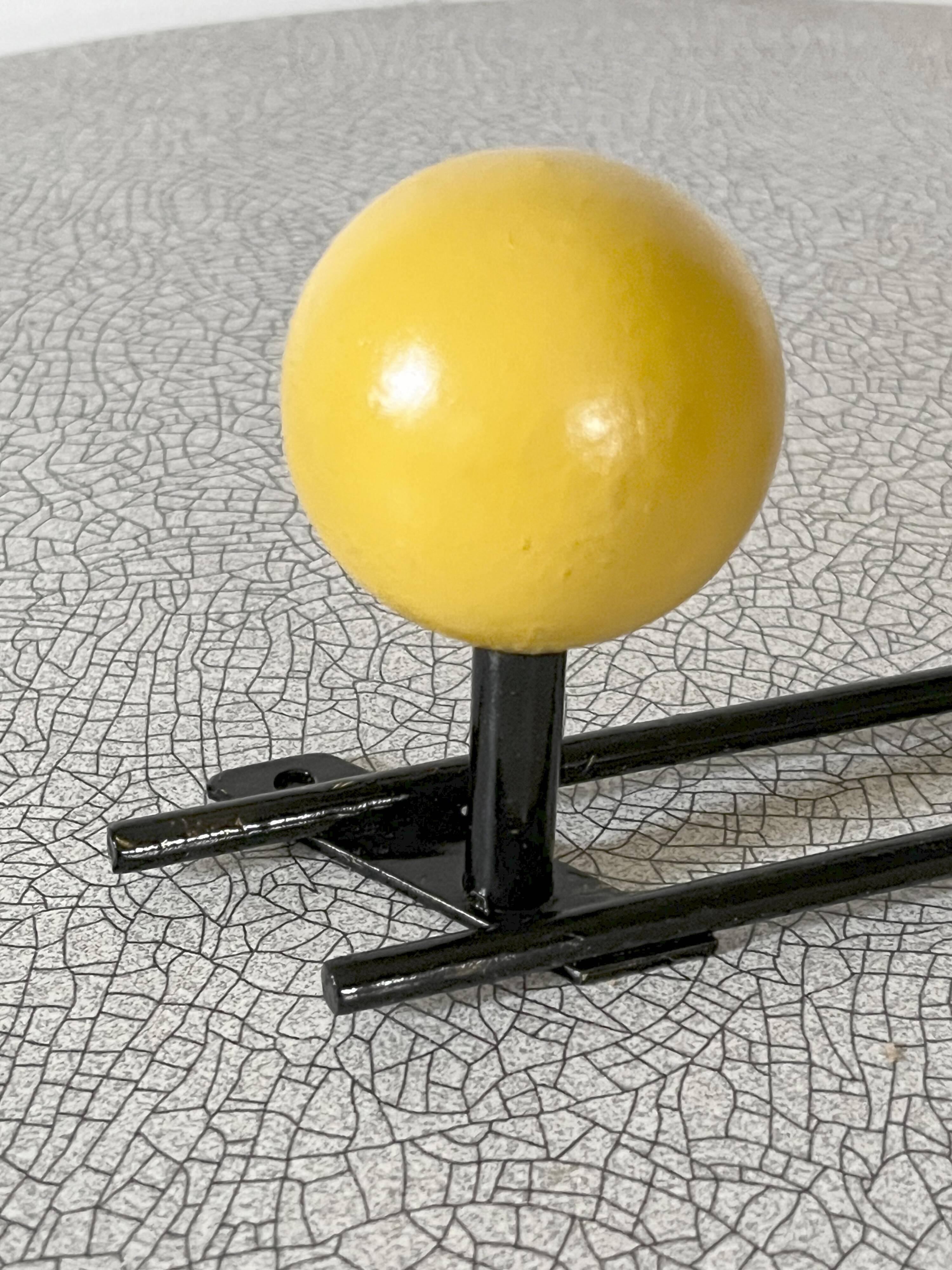 Vintage wall coat rack, metal and wood in yellow and red.