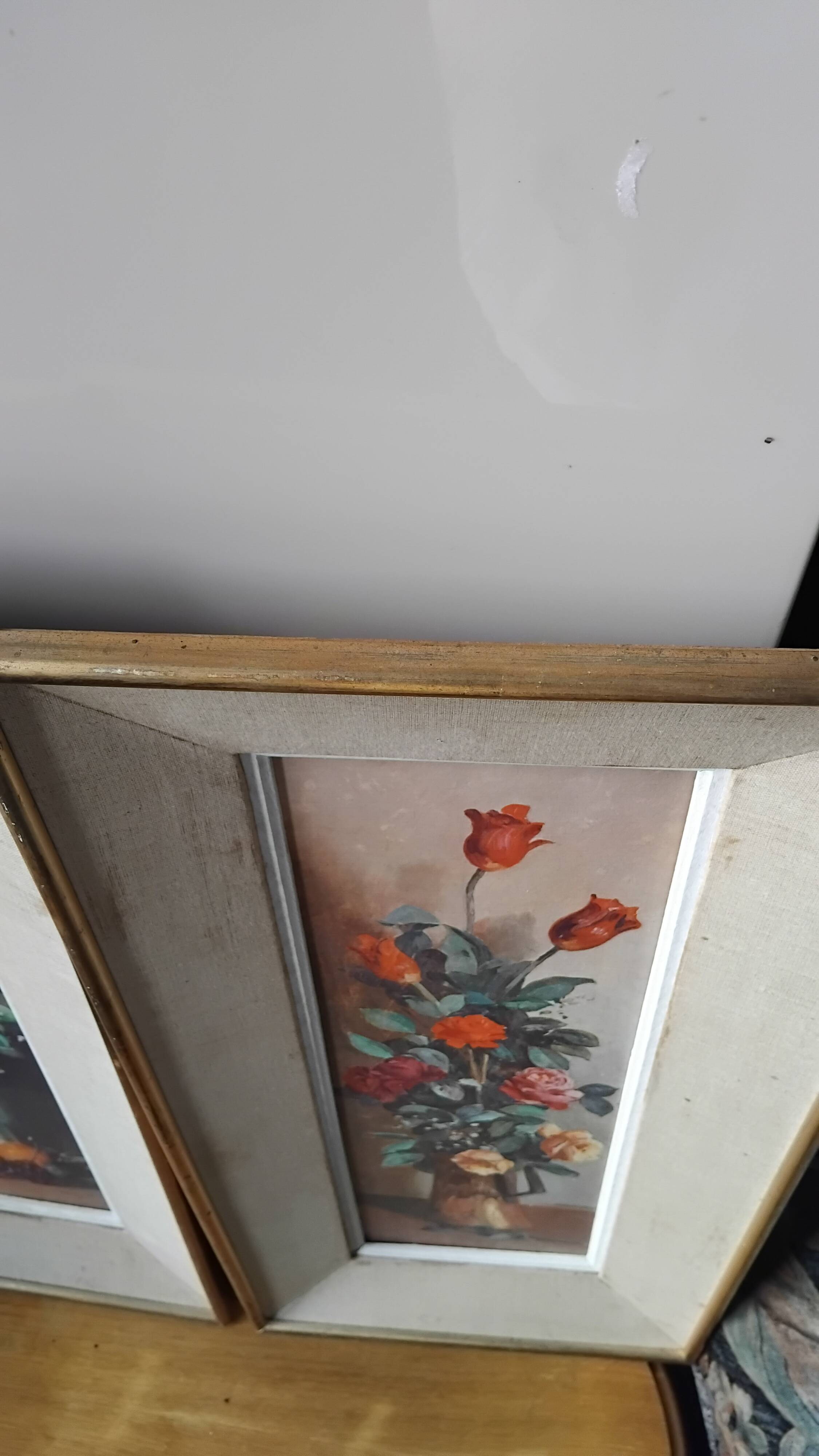 Pair of framed paintings featuring a composition of flowers.