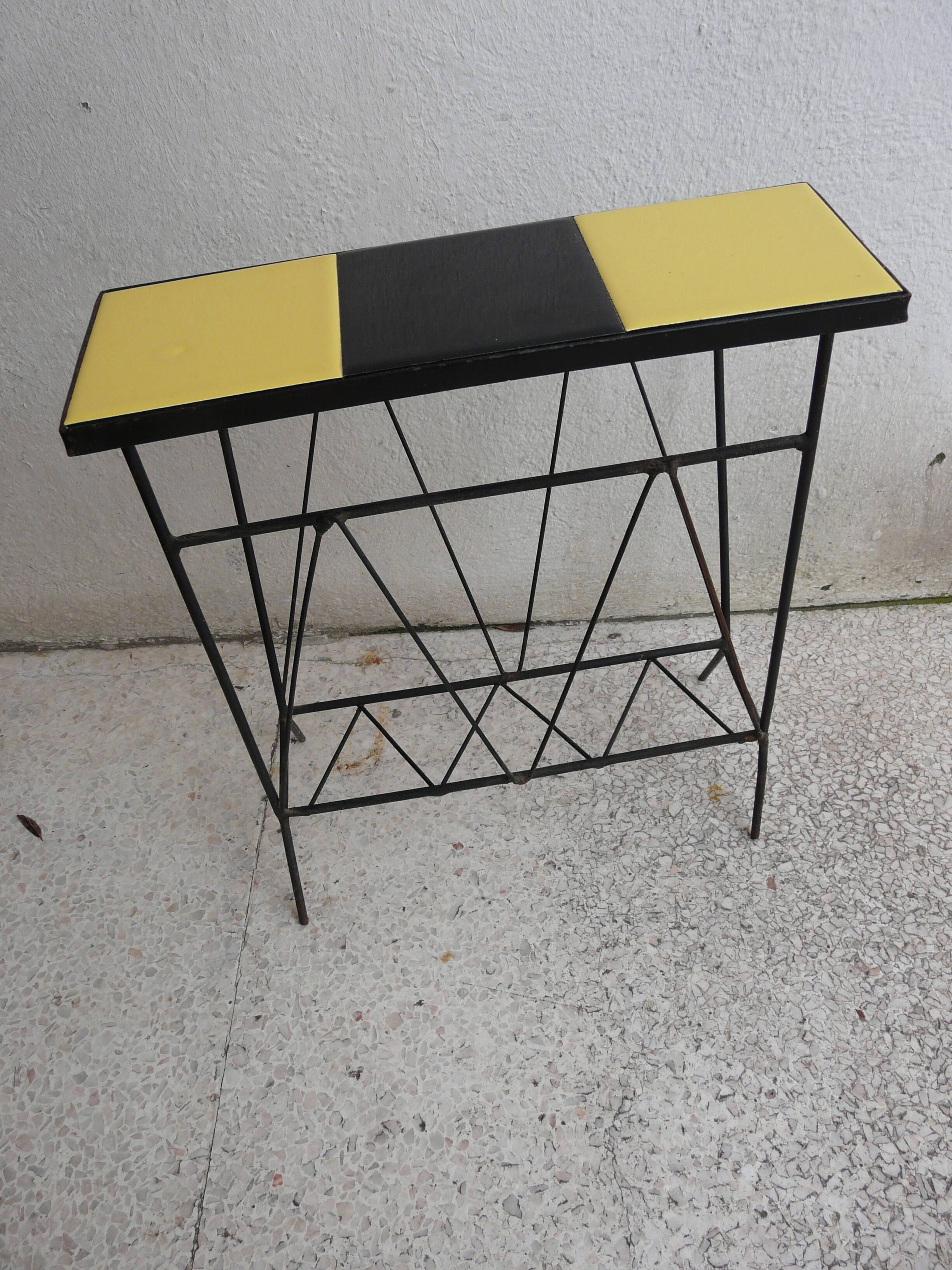 Black metal magazine rack and yellow and black tiled shelf.