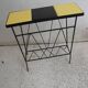 Black metal magazine rack and yellow and black tiled shelf.