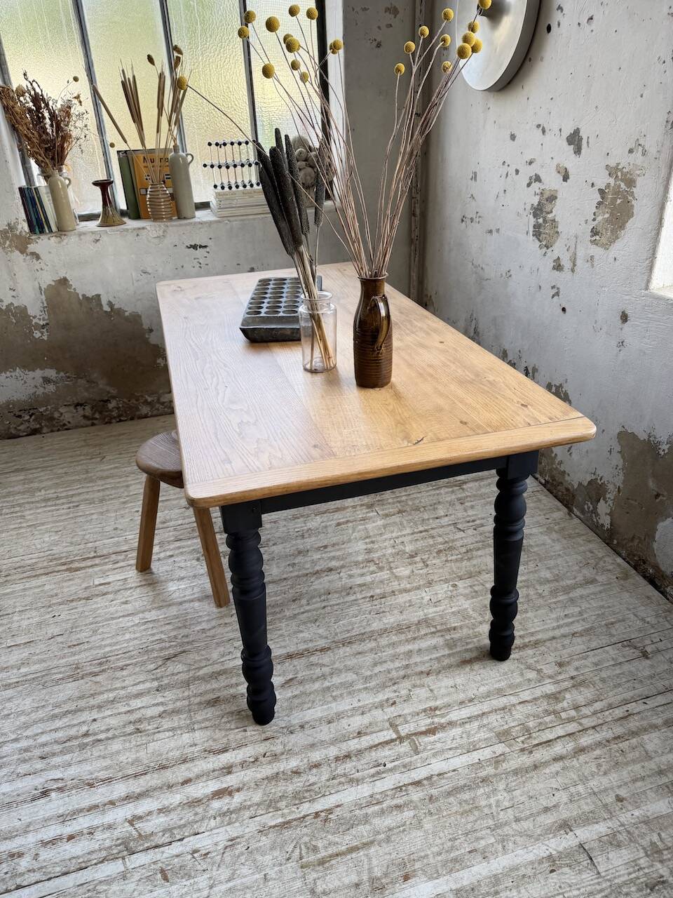 Oak farmhouse table with turned black legs.