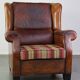 Very large worn sheepskin wing chair with a checked seat cushion