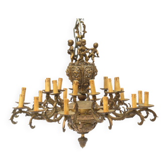 Bronze chandelier with 24 arms of light decorated with putti at the top