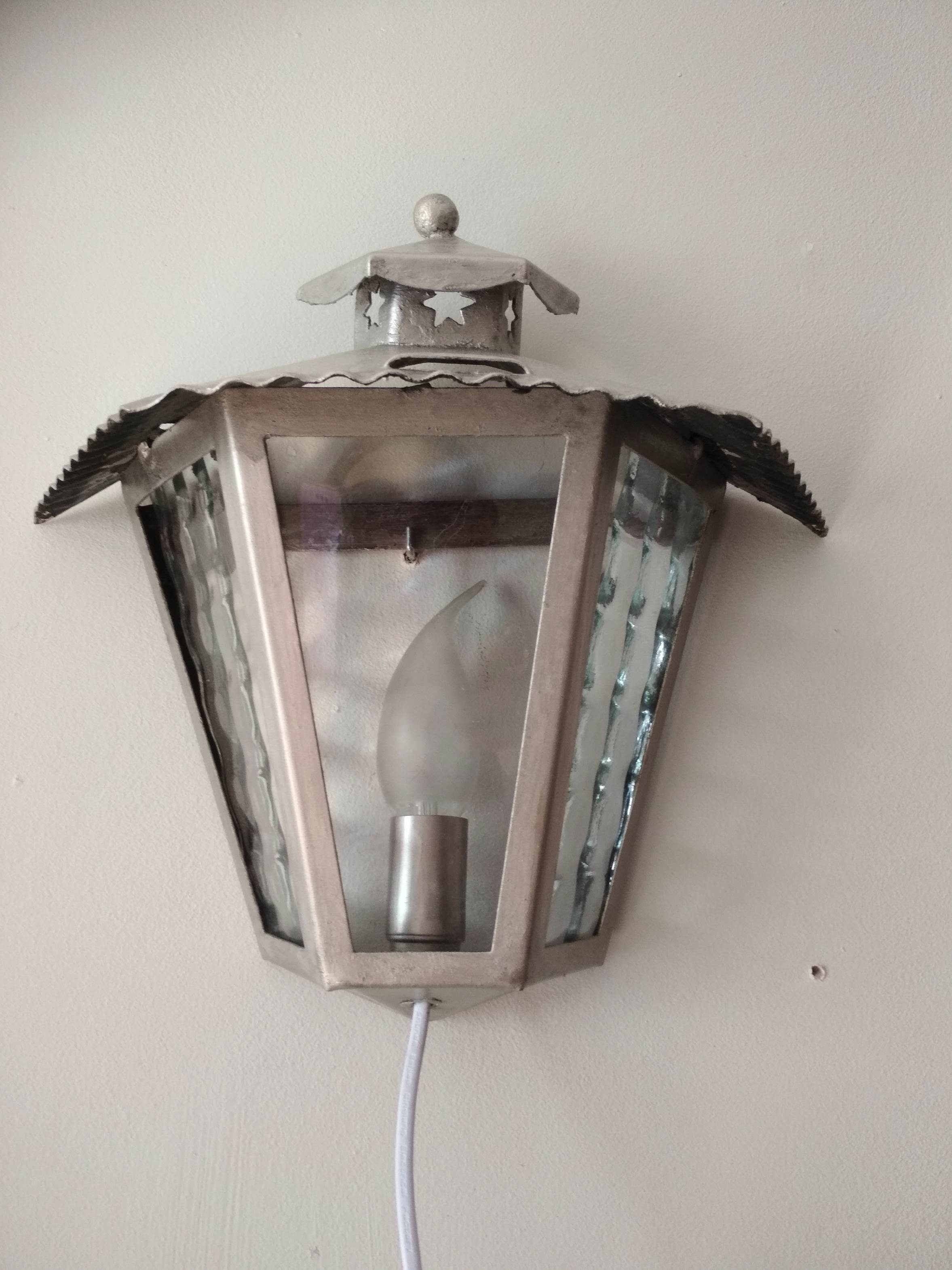 Half grey metal wall sconce and 3 windows