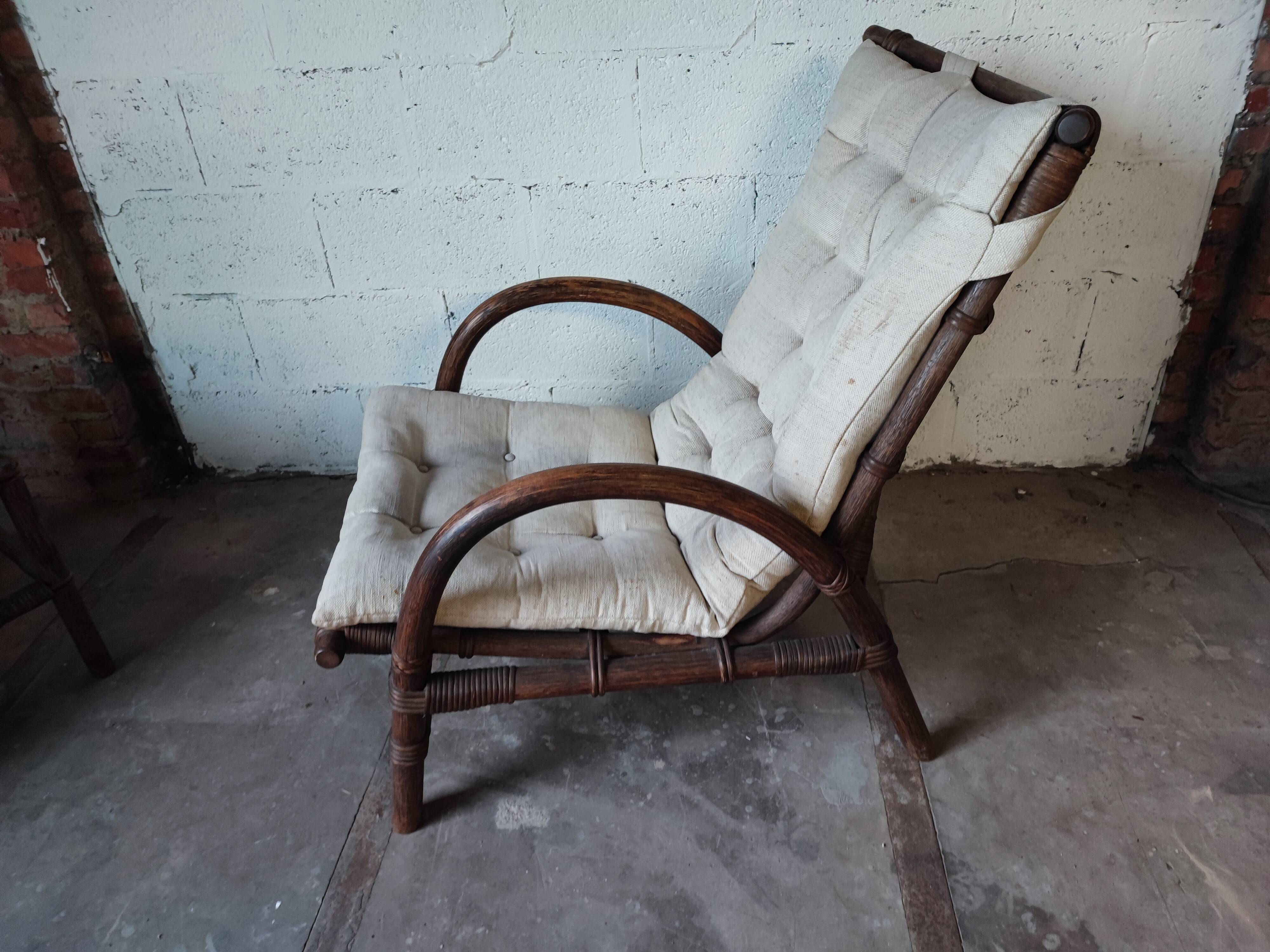 Relaxed armchair in bamboo and rattan with its small side table. Beige linen cushion.