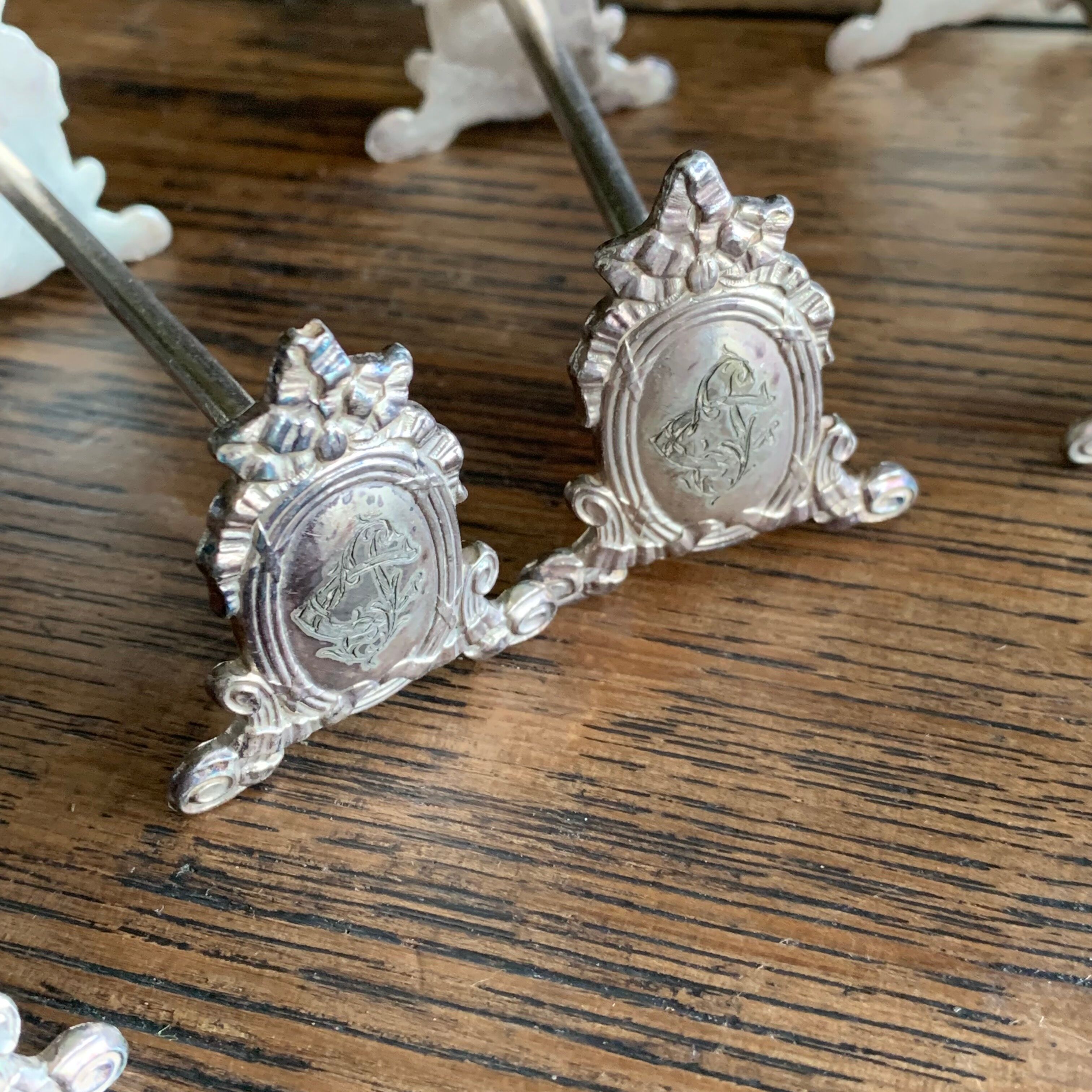 Series of 12 monogrammed silver metal knife holders