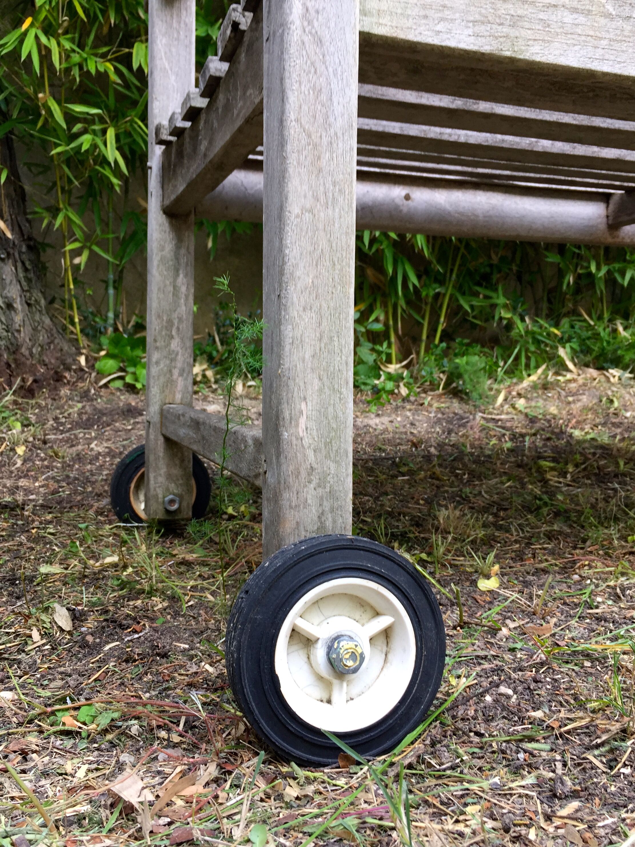 Vintage wooden garden bench with wheels
