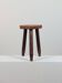 Vintage three-legged wooden milk stool in brutalist style with sculpted decoration.