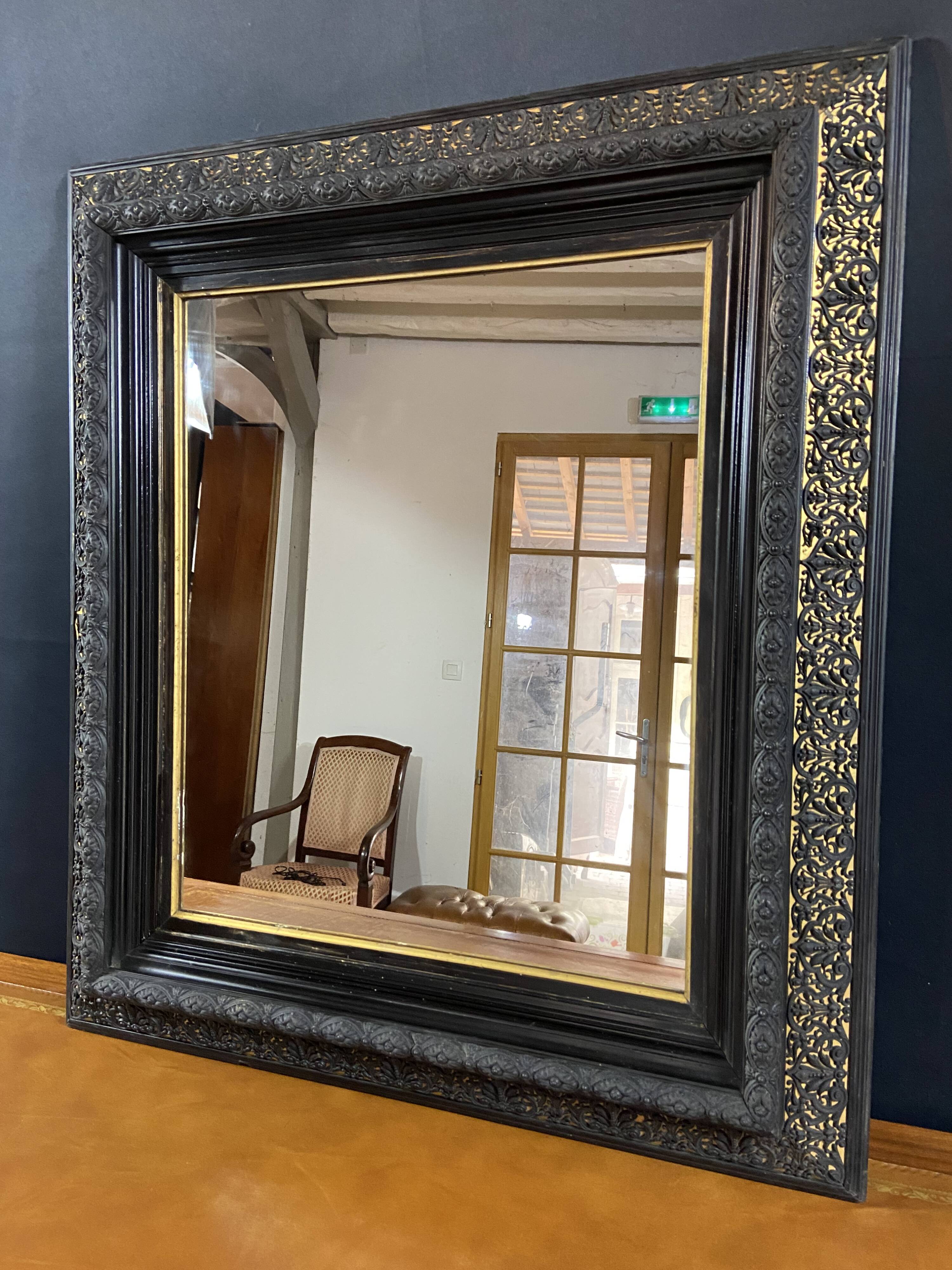 19th-century mirror Napoleon III in blackened wood on a gold background.