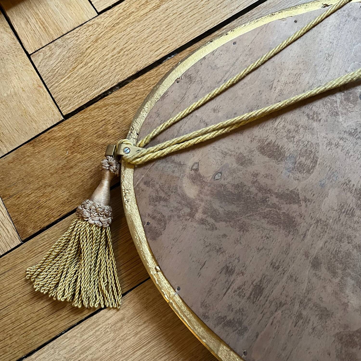 Antique oval beveled mirror adorned with tassels