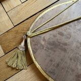 Antique oval beveled mirror adorned with tassels