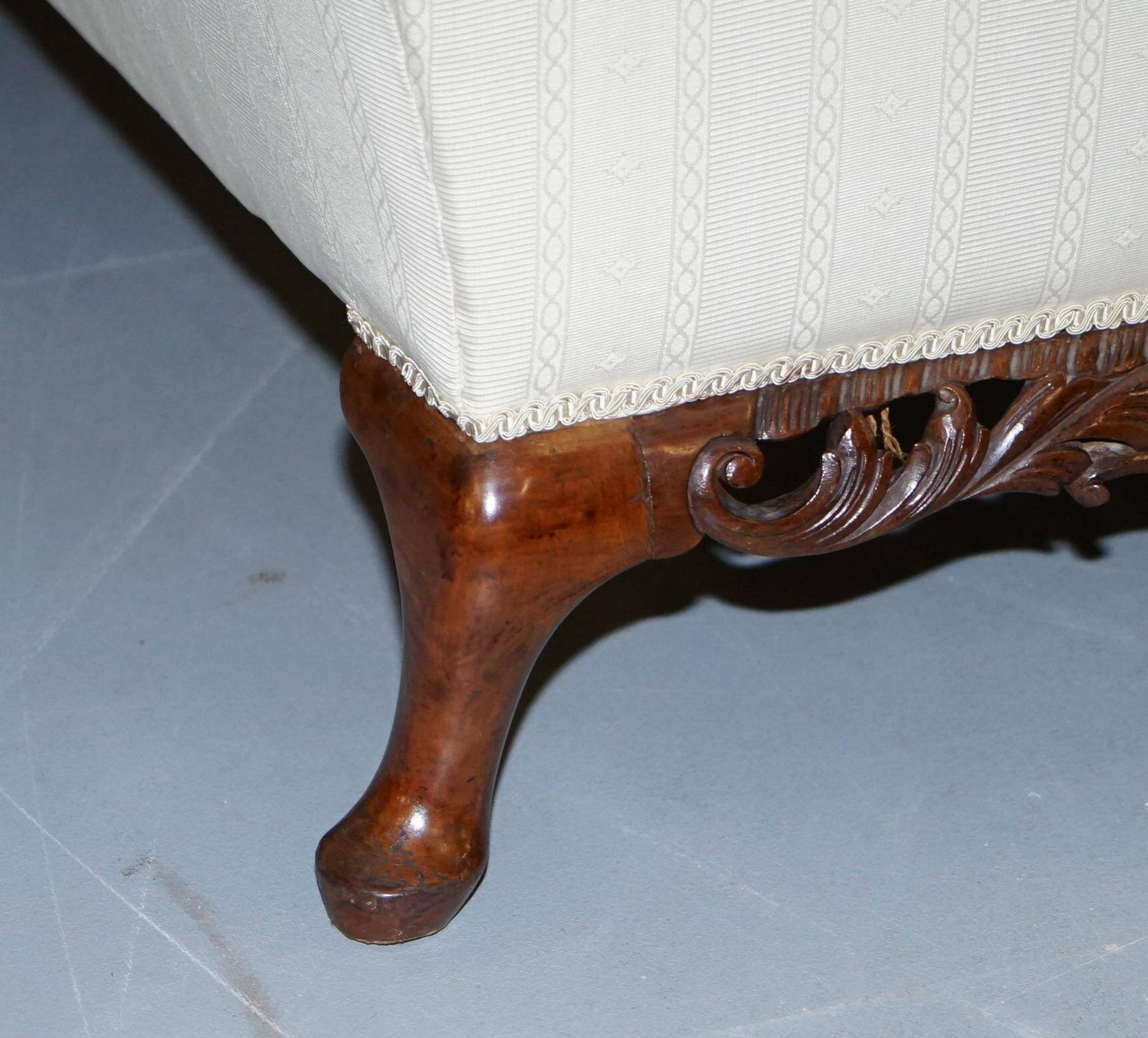 Three-seater canapé carved from solid walnut with claw feet.