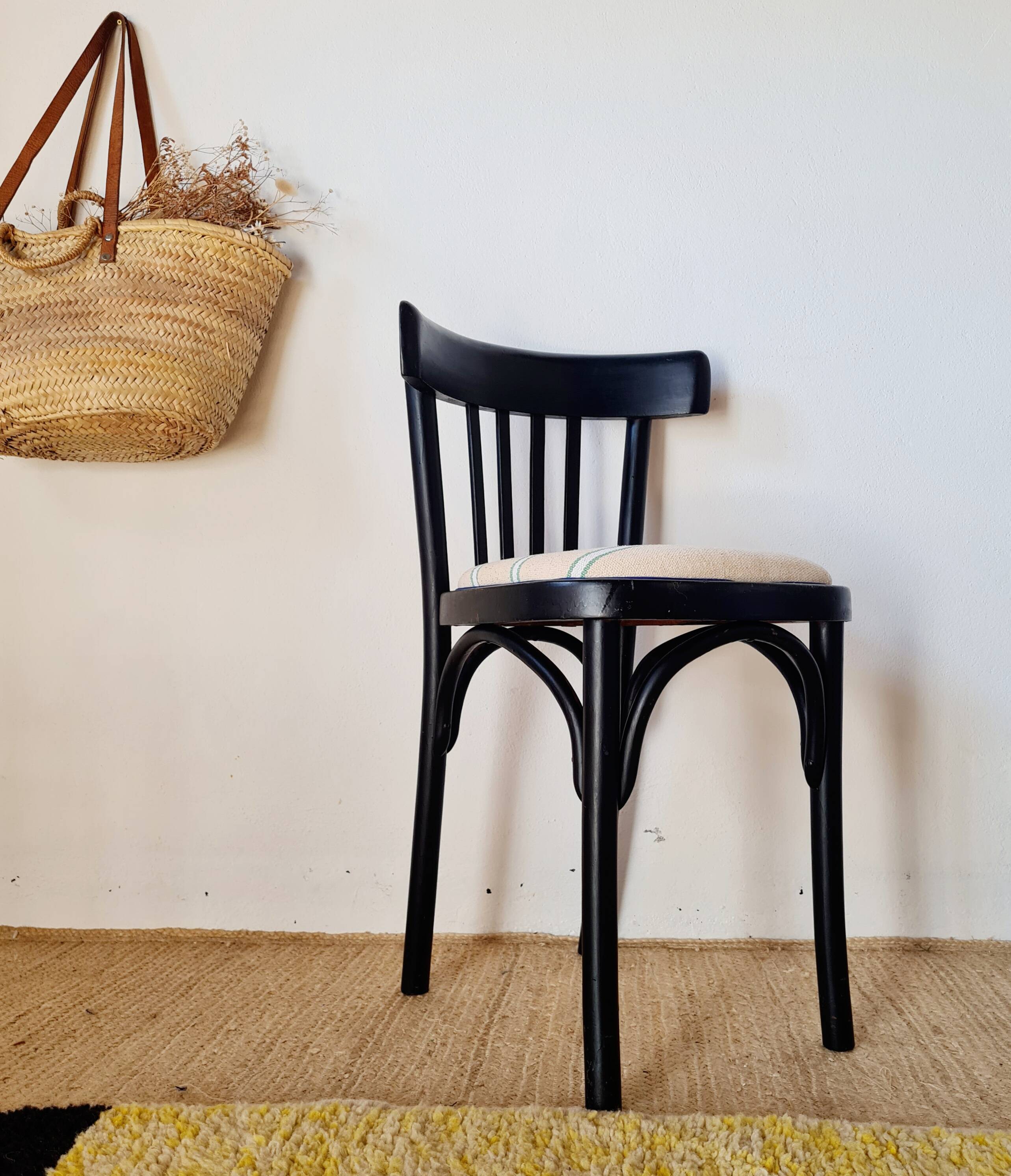 Curved black wooden bistro chair with striped seat