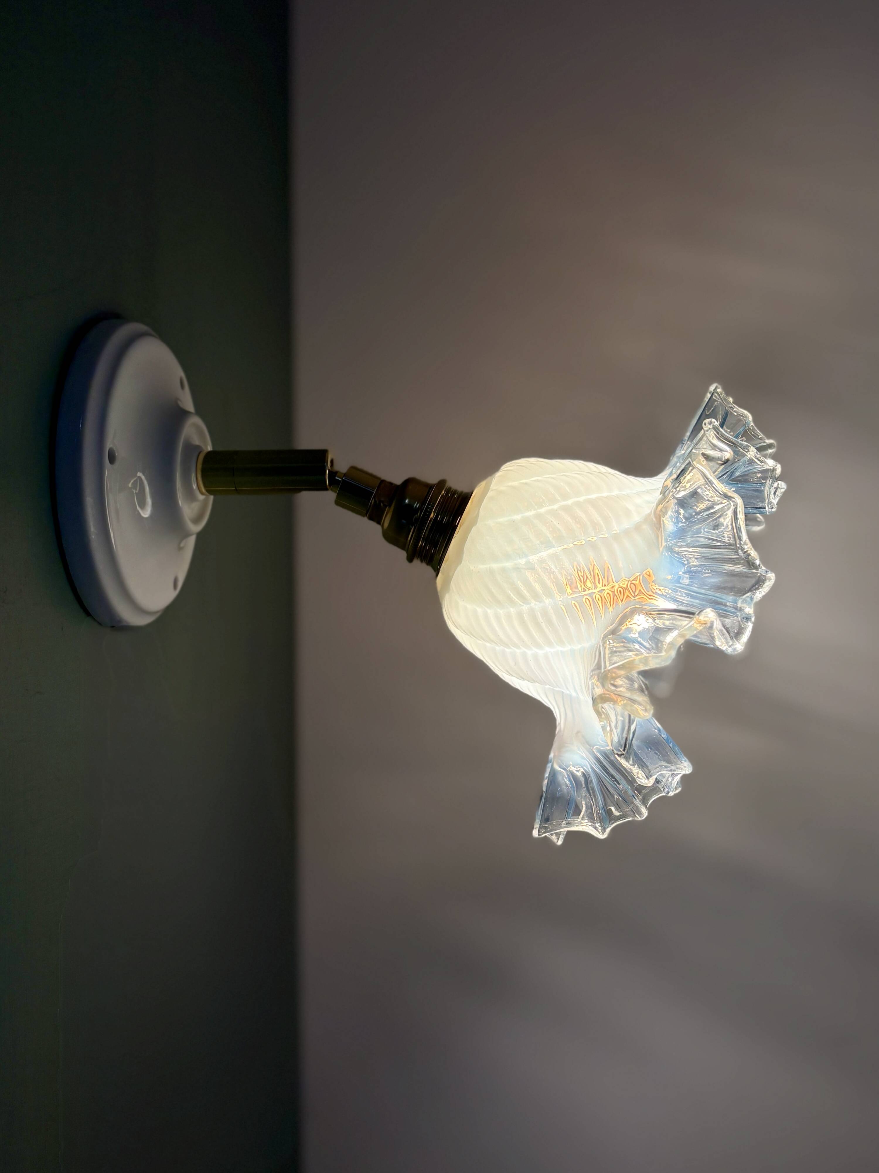 Vintage tulip glass wall light in transparent, slightly pearlescent white.