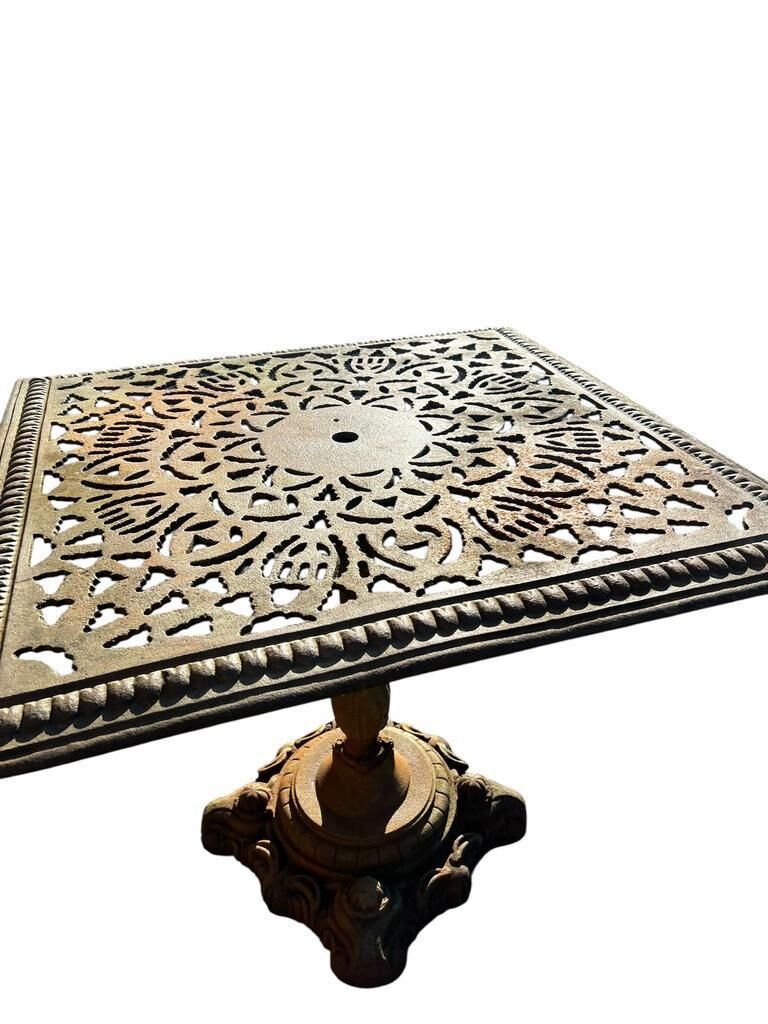 Antique cast iron garden table with decorative openwork top.