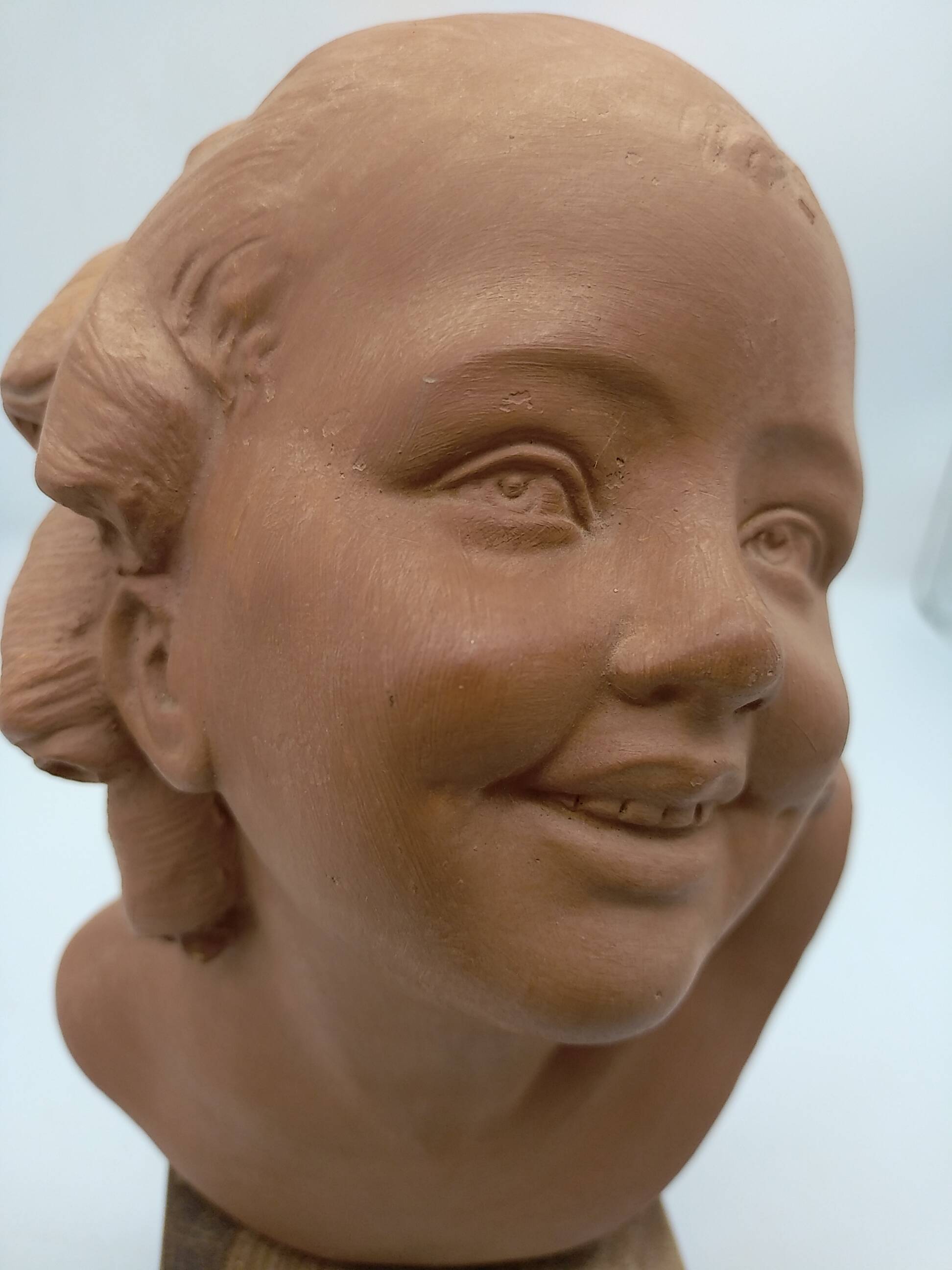 Bust young smiling girl. Circa 1900. Art Deco. Signed.