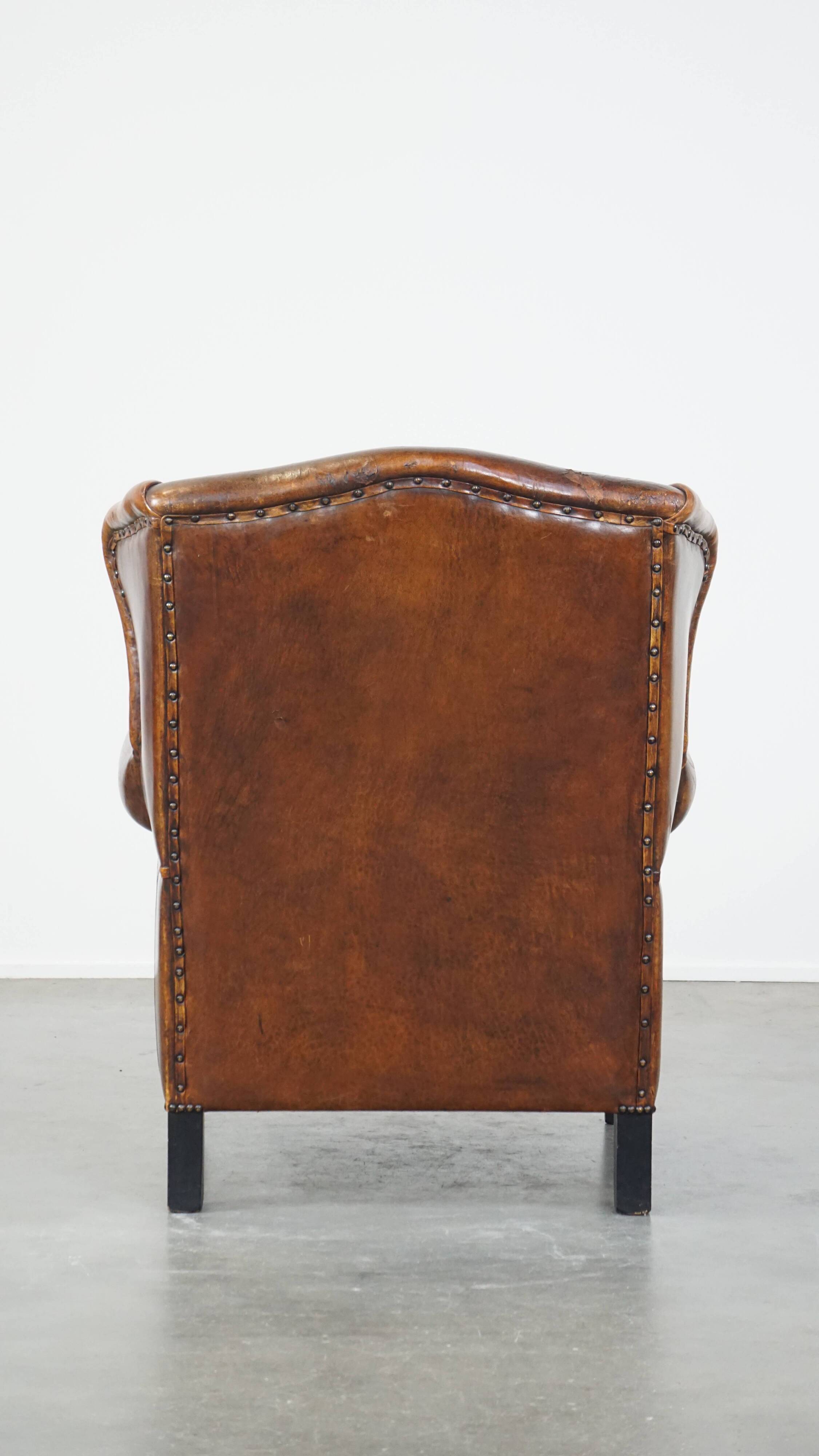 Sheepskin leather wingback chair with a red corduroy seat cushion