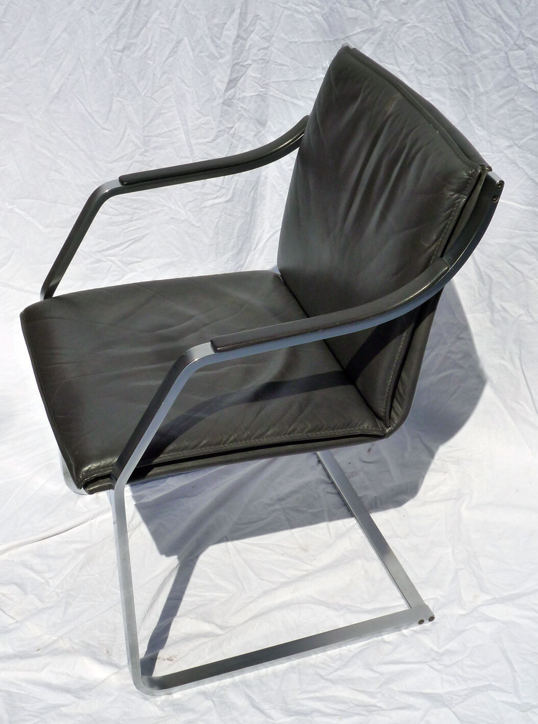 Chair with steel and leather armrests