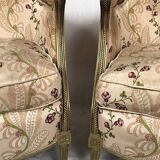 Paire de bergères en bois doré garnies de soie à motifs de fleurs, art déco d’inspiration Louis XVI