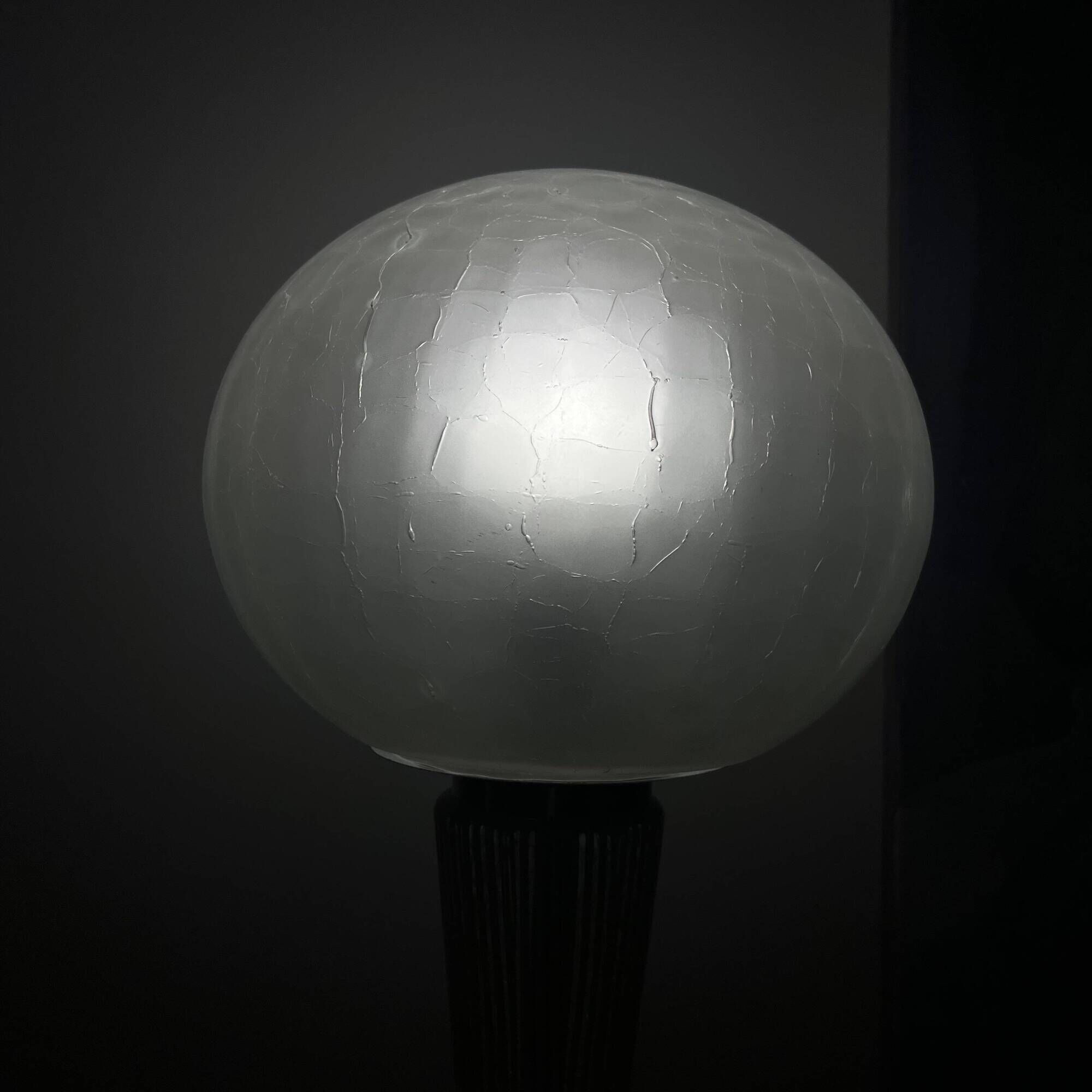Large globe table lamp with a cracked glass base and brass stand.