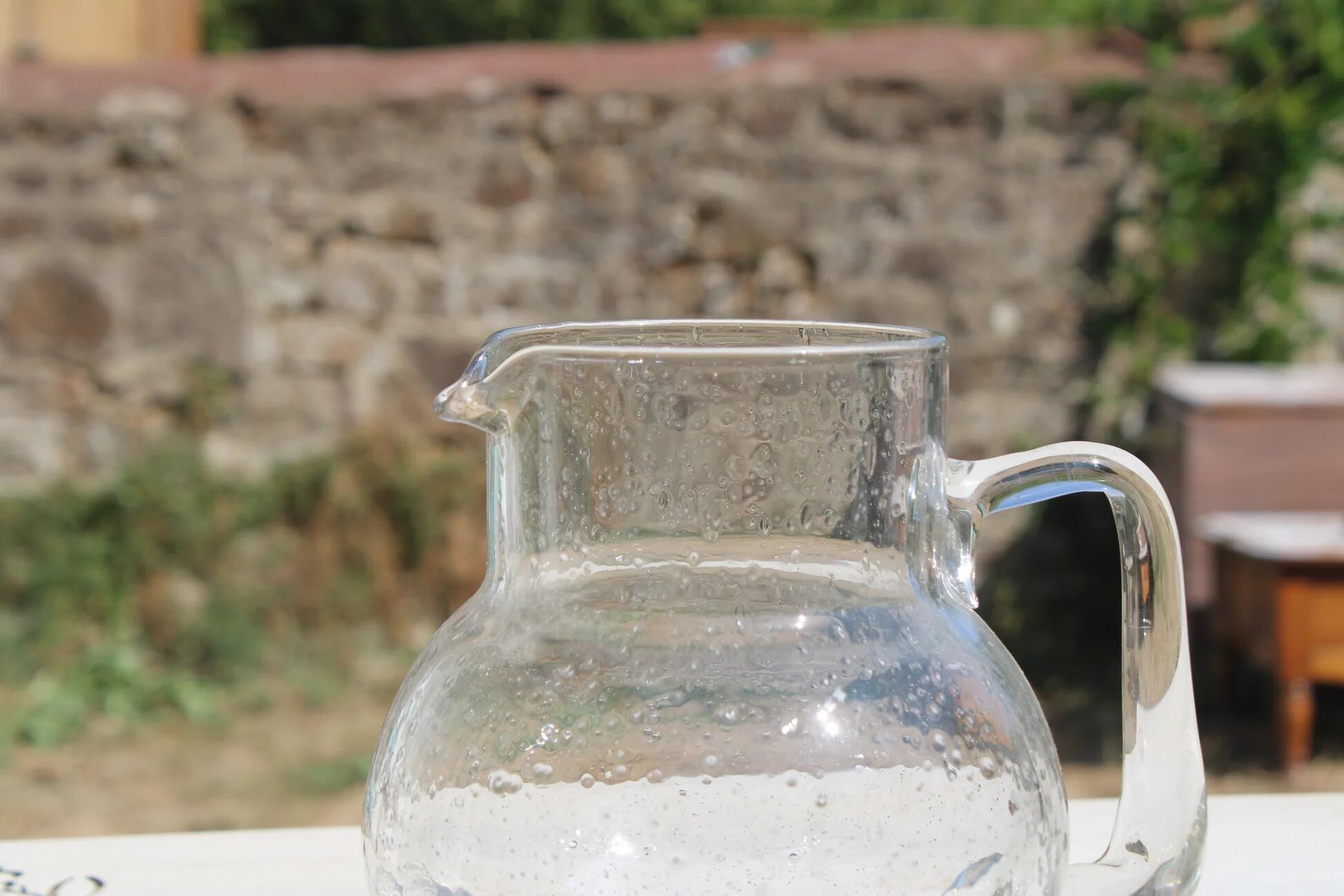 Vintage blown glass pitcher with bubbles, transparent.