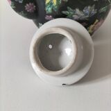 Vintage Chinese teapot with floral polychrome decoration on a black background.