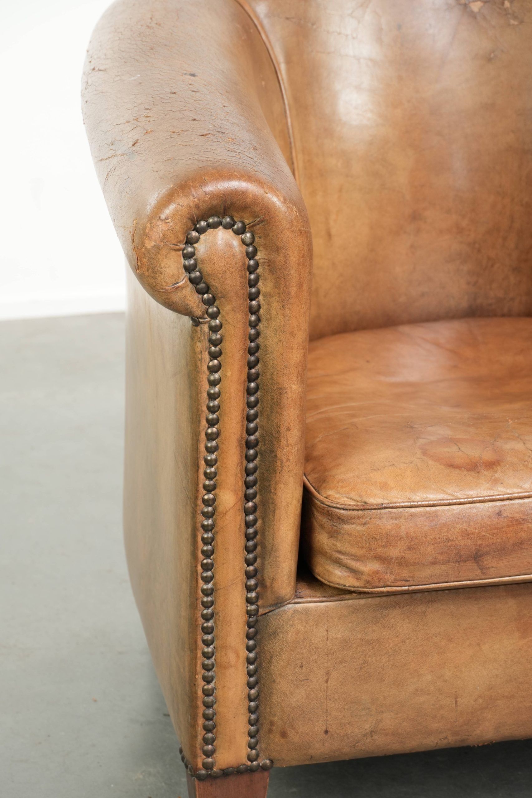 Vintage sheepskin club armchair finished with decorative nails