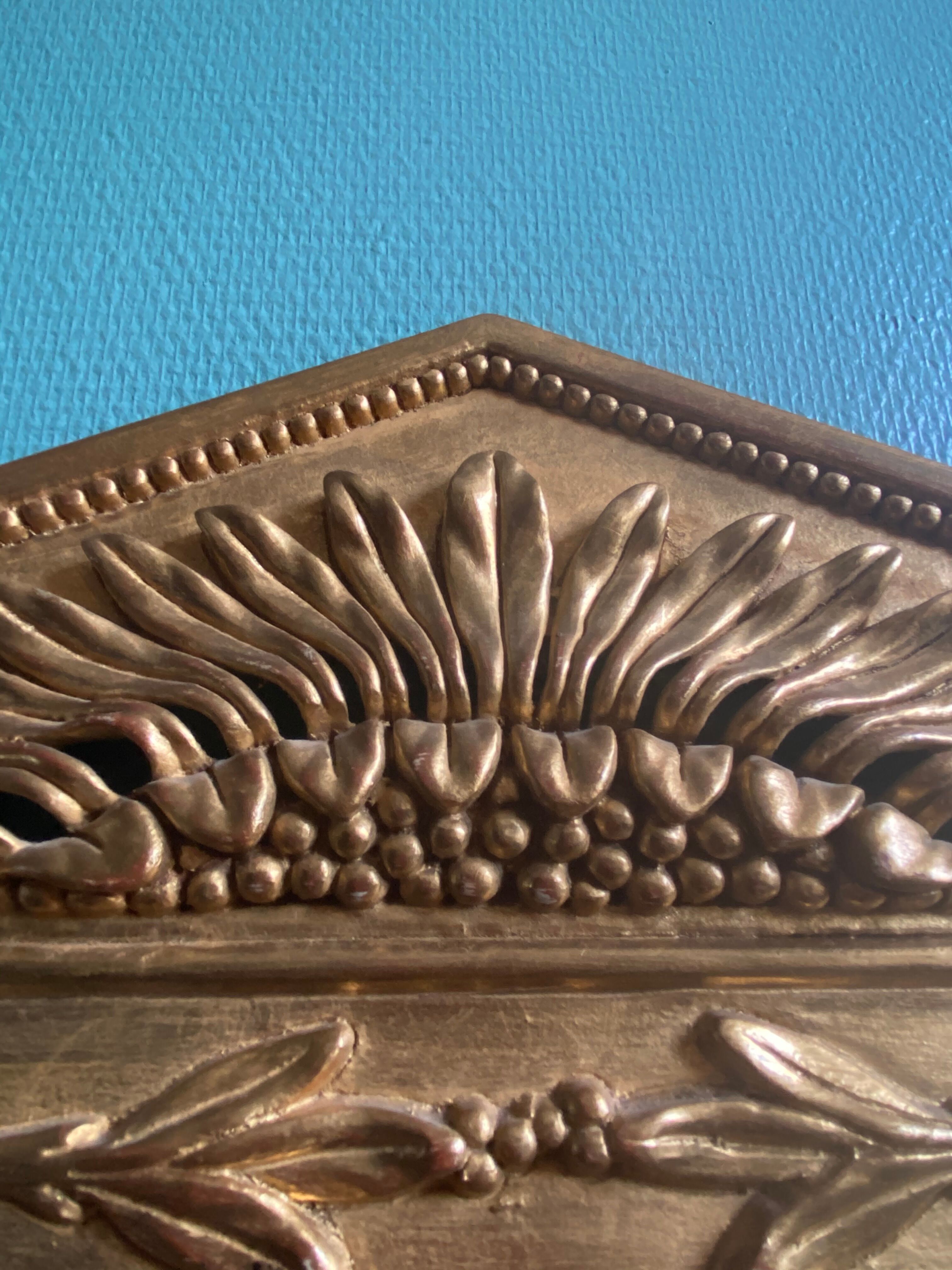 Mirror in gilded wood with a triangle pediment decorated with half sunflowers
