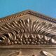 Mirror in gilded wood with a triangle pediment decorated with half sunflowers