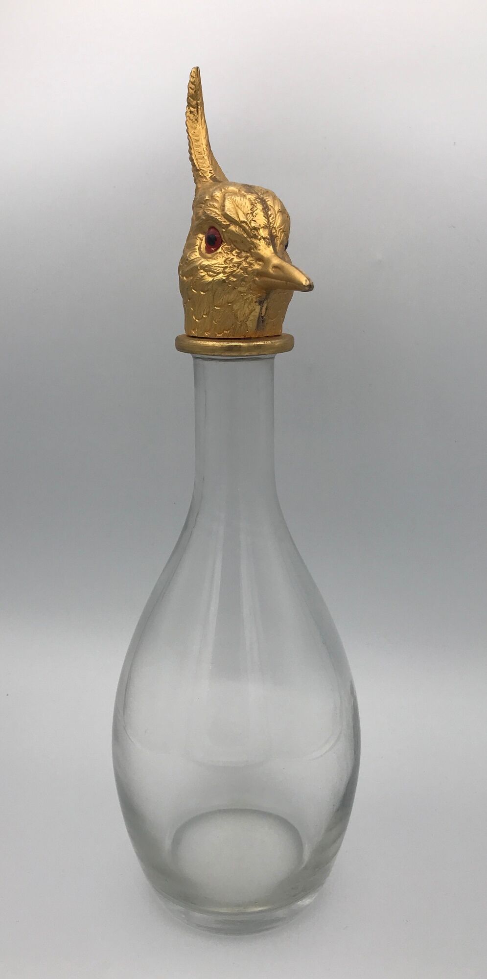 Glass bottle type carafe with gold metal bird head stopper