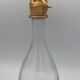 Glass bottle type carafe with gold metal bird head stopper