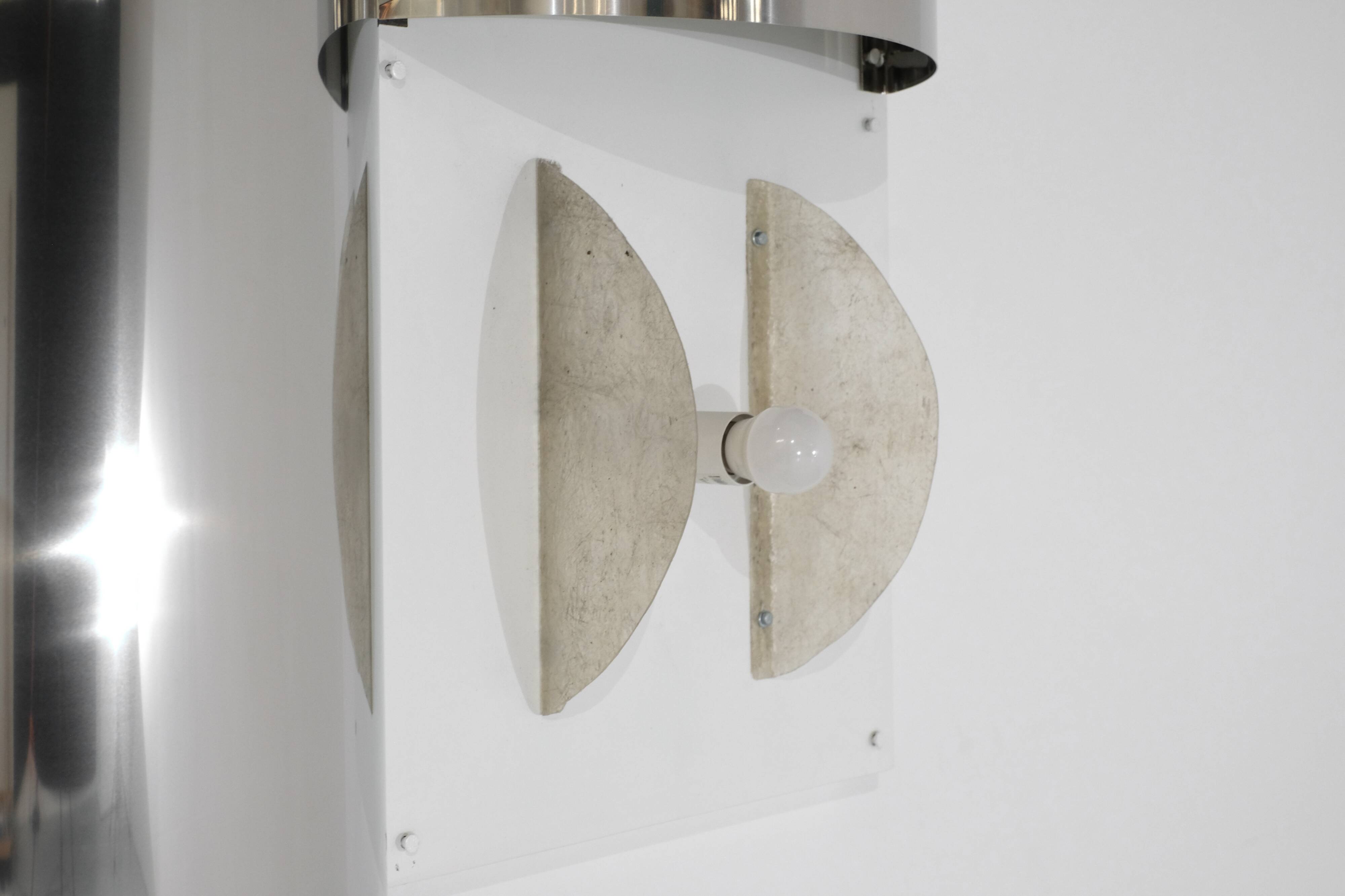 Contemporary wall light in stainless steel and metal.