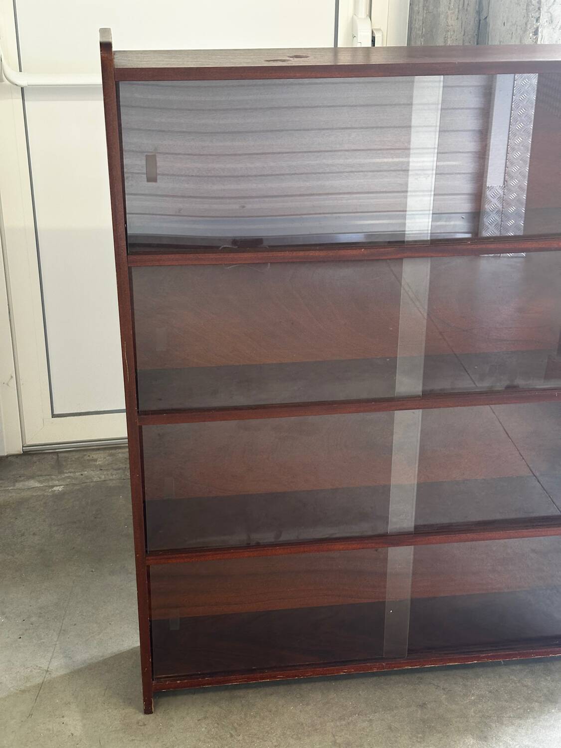 Vintage 1960s wooden library with sliding doors.
