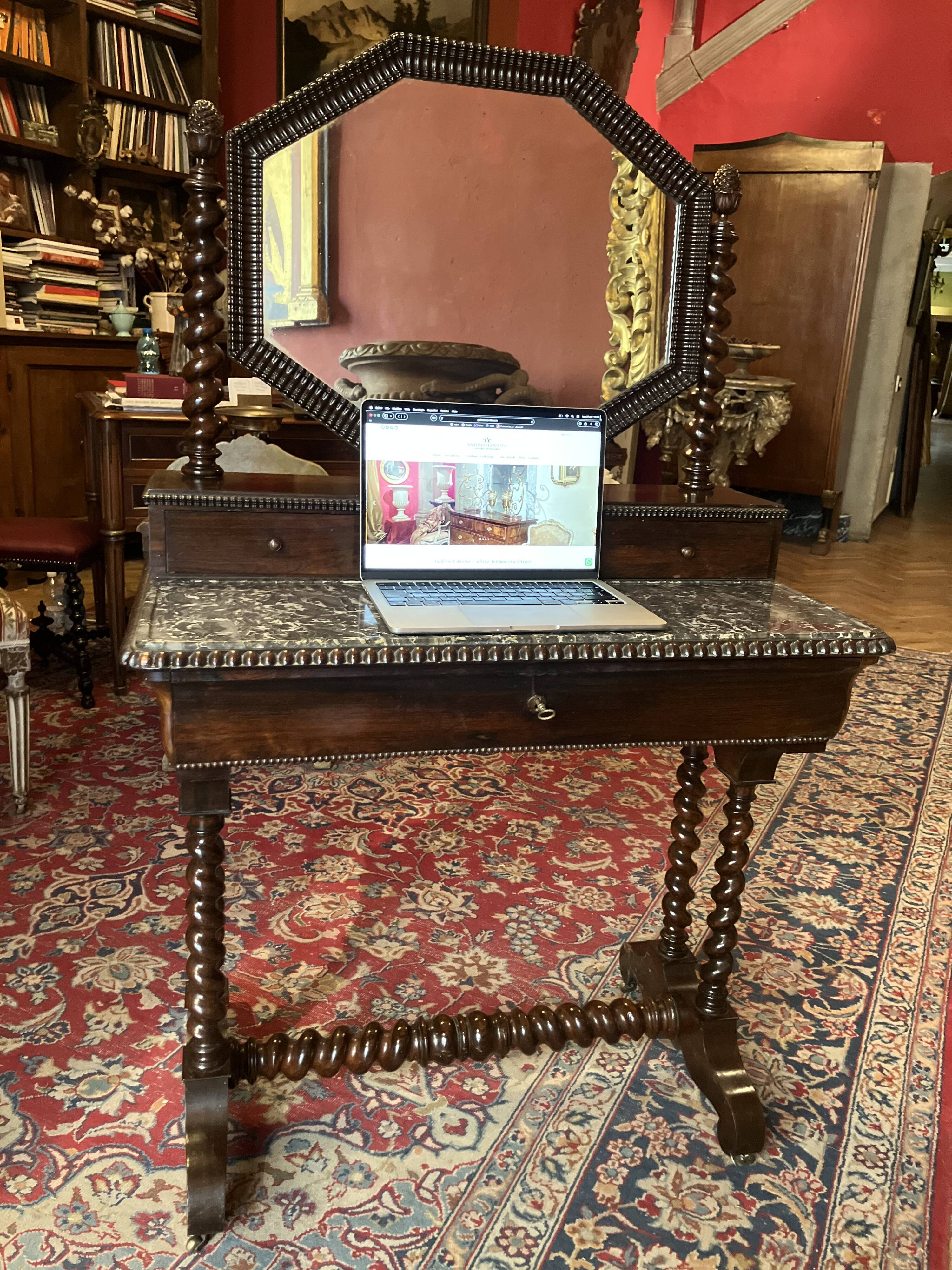 Antique English mahogany dressing table with carved details, black marble, and mirror.