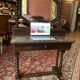 Antique English mahogany dressing table with carved details, black marble, and mirror.