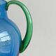 Translucent blue glass jug with a green handle.