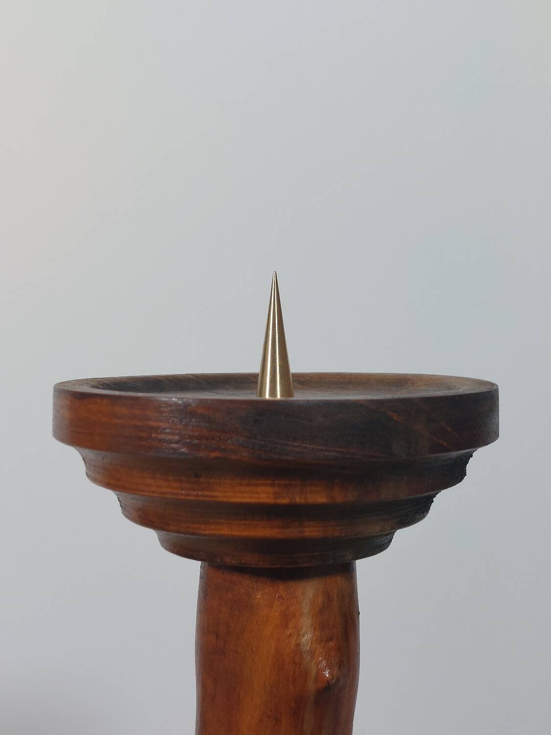 Vintage candle holder in an organic shape with a brass spike and tiered top.