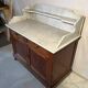 Antique wood and marble kitchen sideboard with carved backsplash