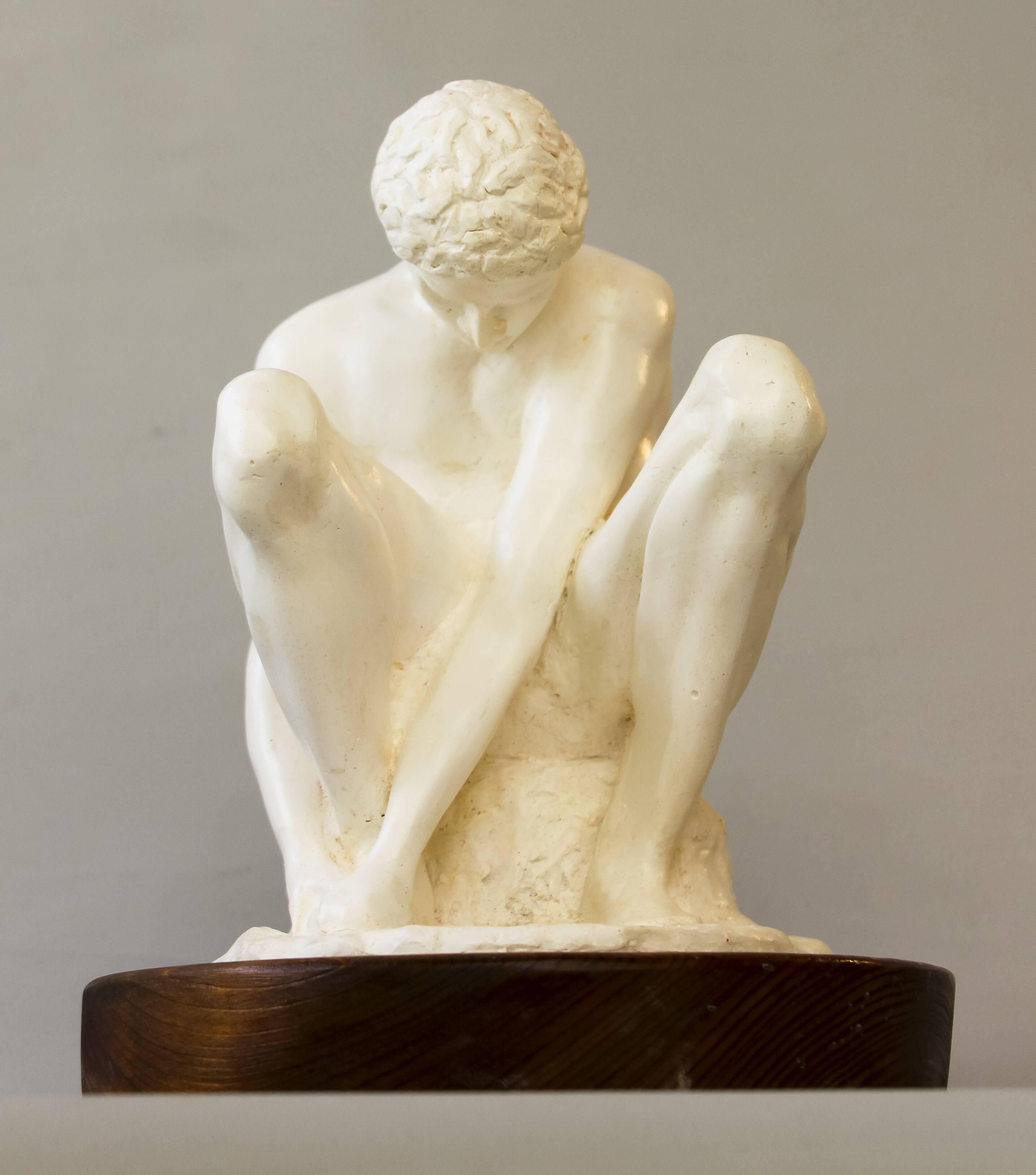 Sculpture of a seated man. Classical male sculpture. Male figure.