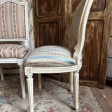 Pair of Louis XVI style chairs in painted wood and satin, classic elegance.