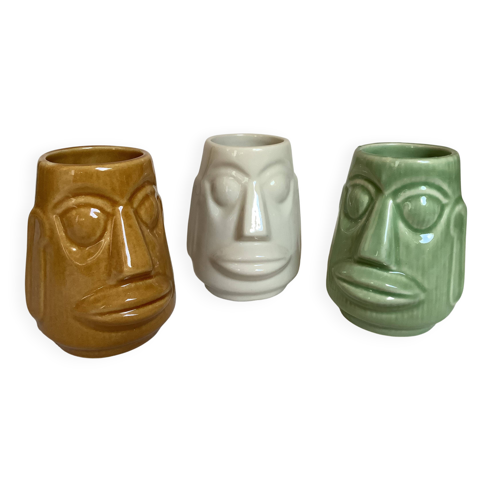 Set of three small Moai-style head vases.