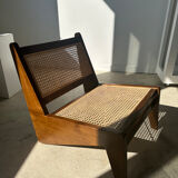 Reclined armchair in canned teak in natural wood