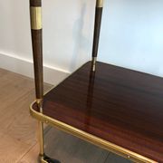 Mahogany and brass rolling table in the style of Maison Jansen.