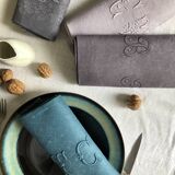 Set of four old damasked and monogrammed towels, tinted multiple colors