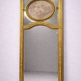 Very large mirror with mouldings, richly carved and gilded, in the Louis XVI style.